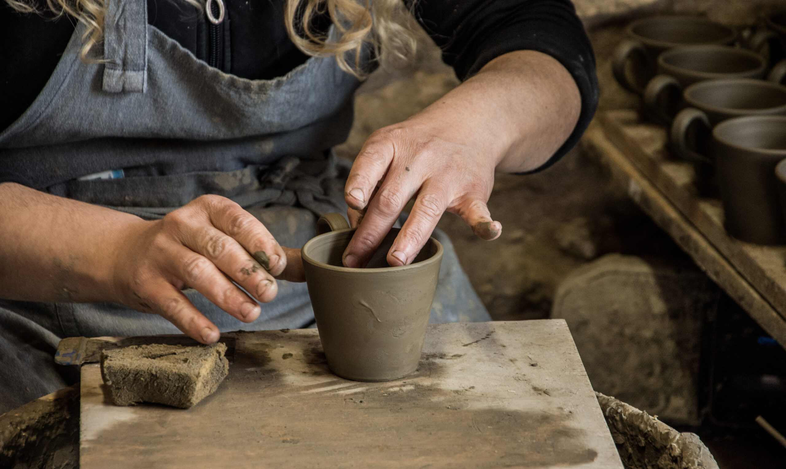 woman potter at work creating some traditional cups of white clay, margarites, rethimno, crete.