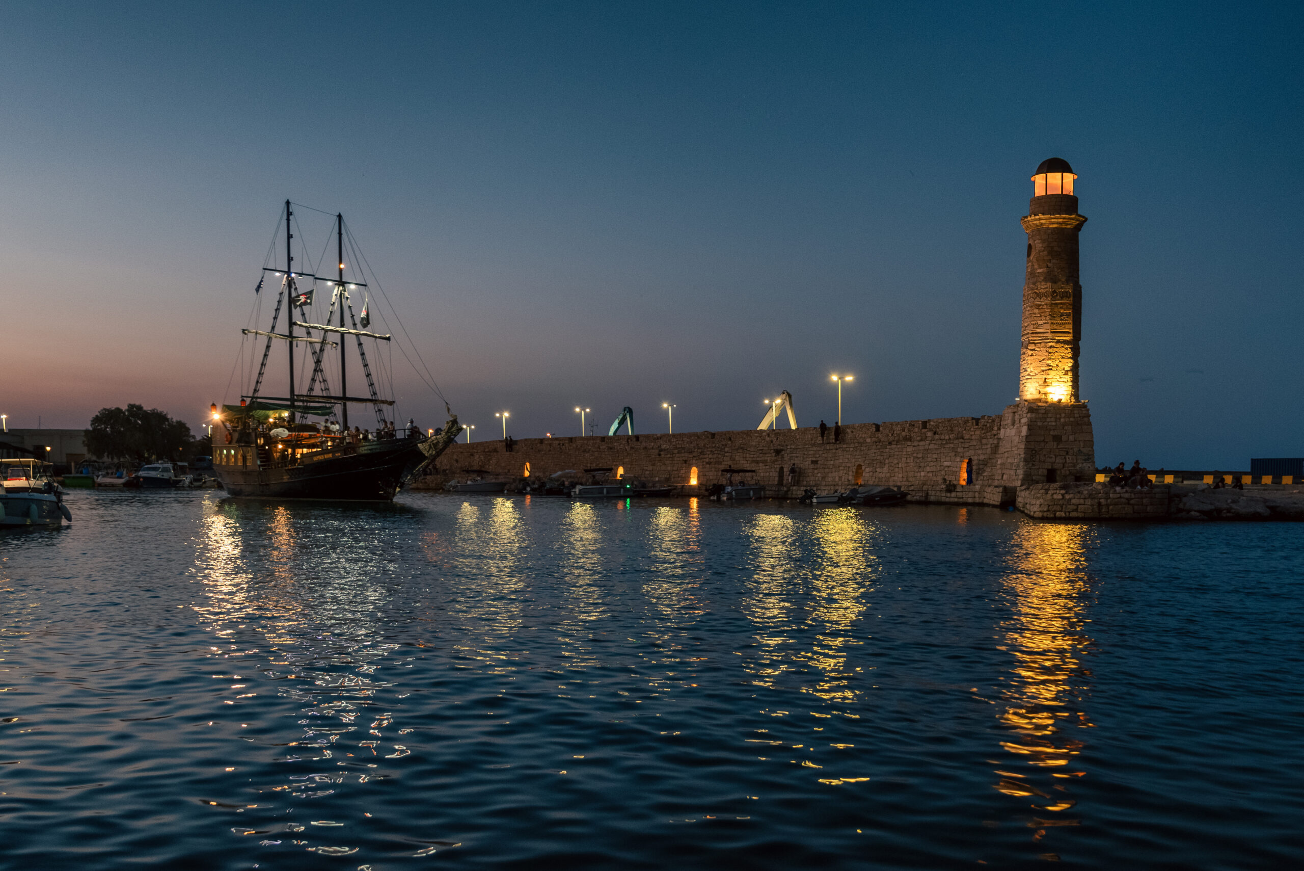 evening harbor with lighthouse and ship in rethymno crete greece